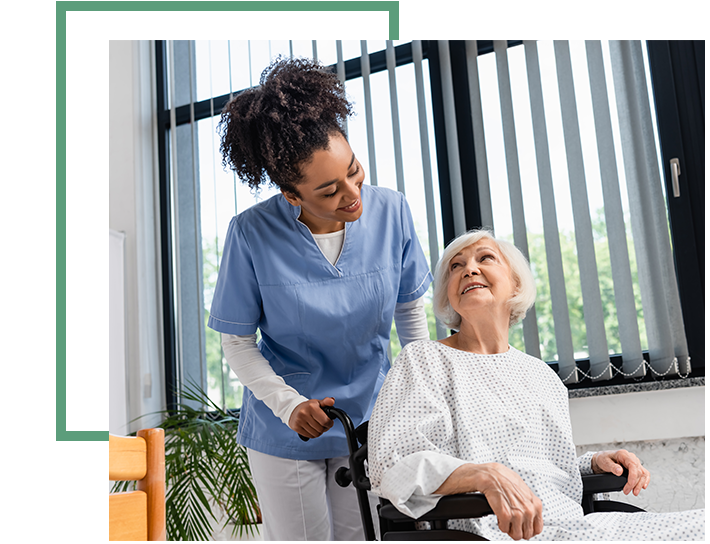 caring nurse with pushing elderly woman in a wheelchair